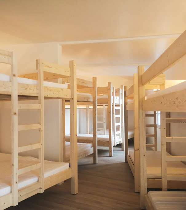 Le dortoir et ses lits superposés en bois clair